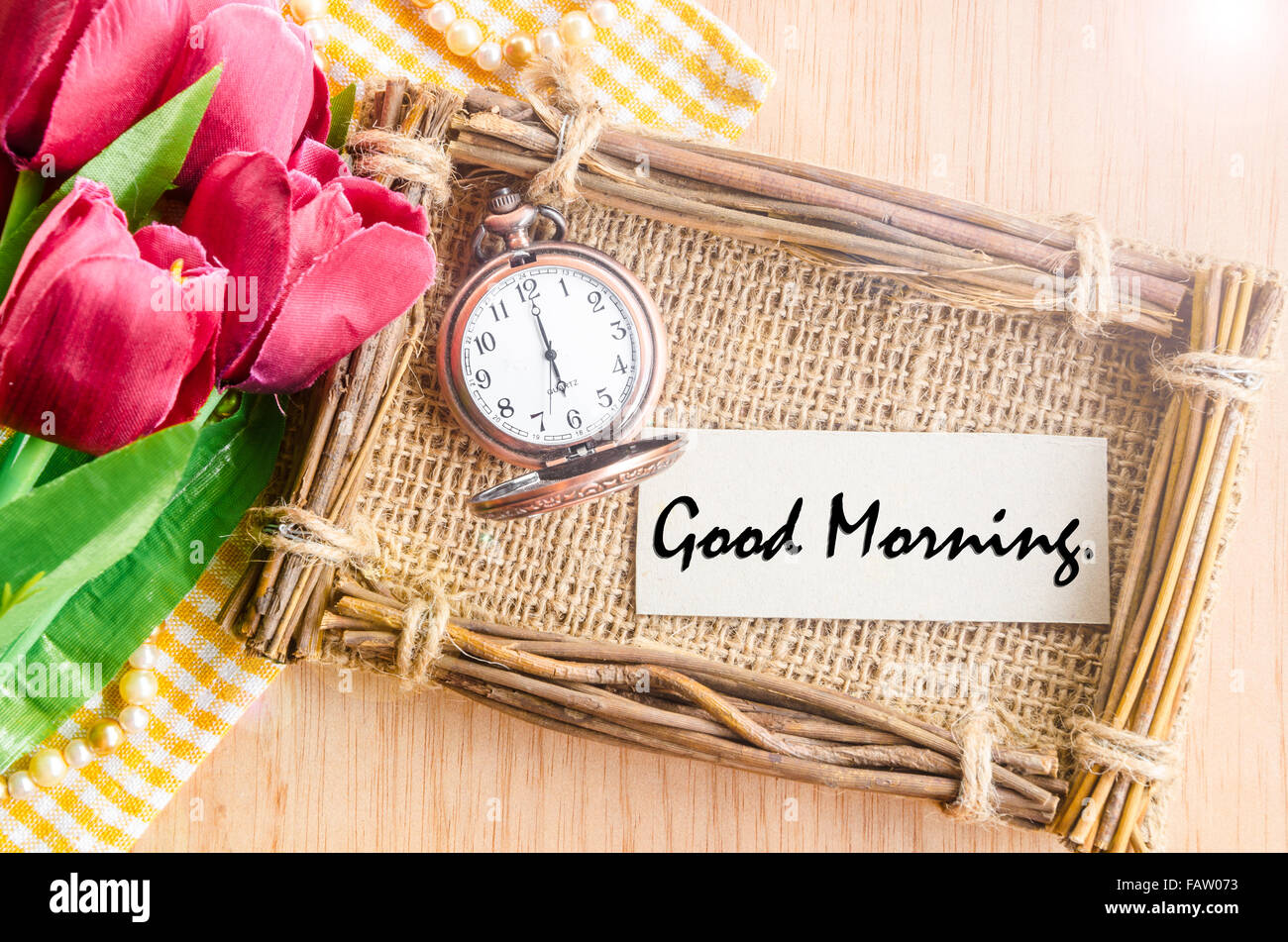 Buona mattina tag carta nel sacco photo frame e vintage orologio sveglia con red tulip su sfondo di legno. Foto Stock