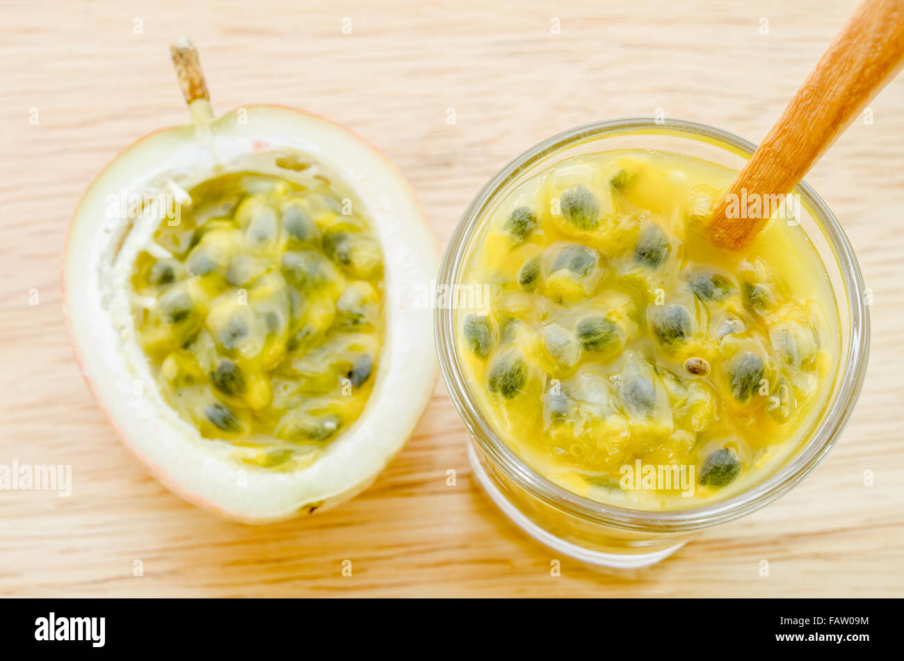 Passione naturale succo di frutta in vetro con il cucchiaio di legno sul tavolo di legno. Foto Stock