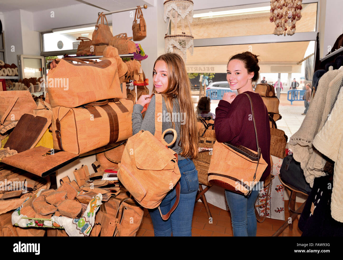 Il Portogallo, Algarve: Ragazze in posa con sughero realizzati borsette in negozio di souvenir di Armacao de Pera Foto Stock