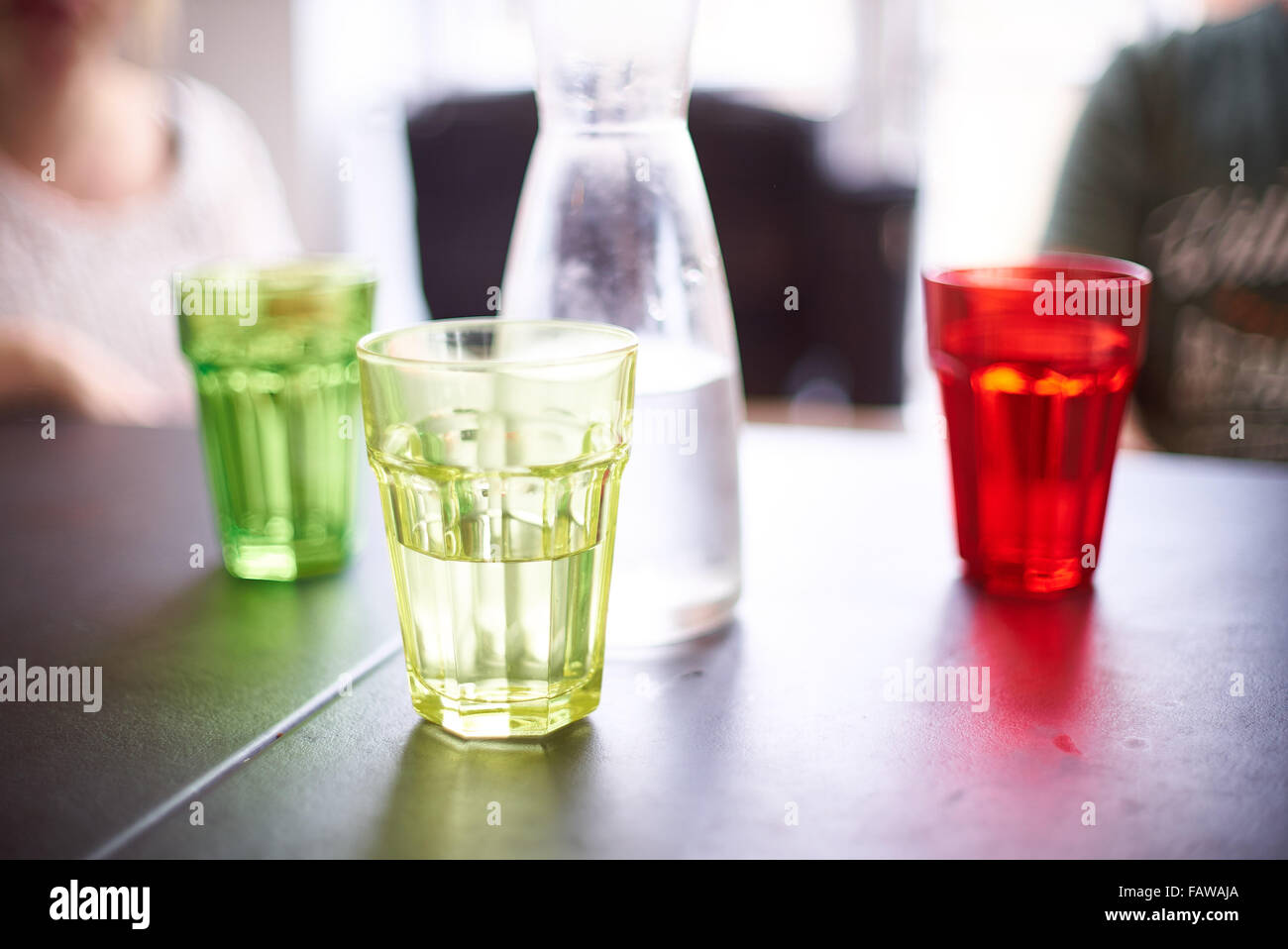 Acqua colorata di occhiali o nottolini su un tavolo del bar Foto Stock