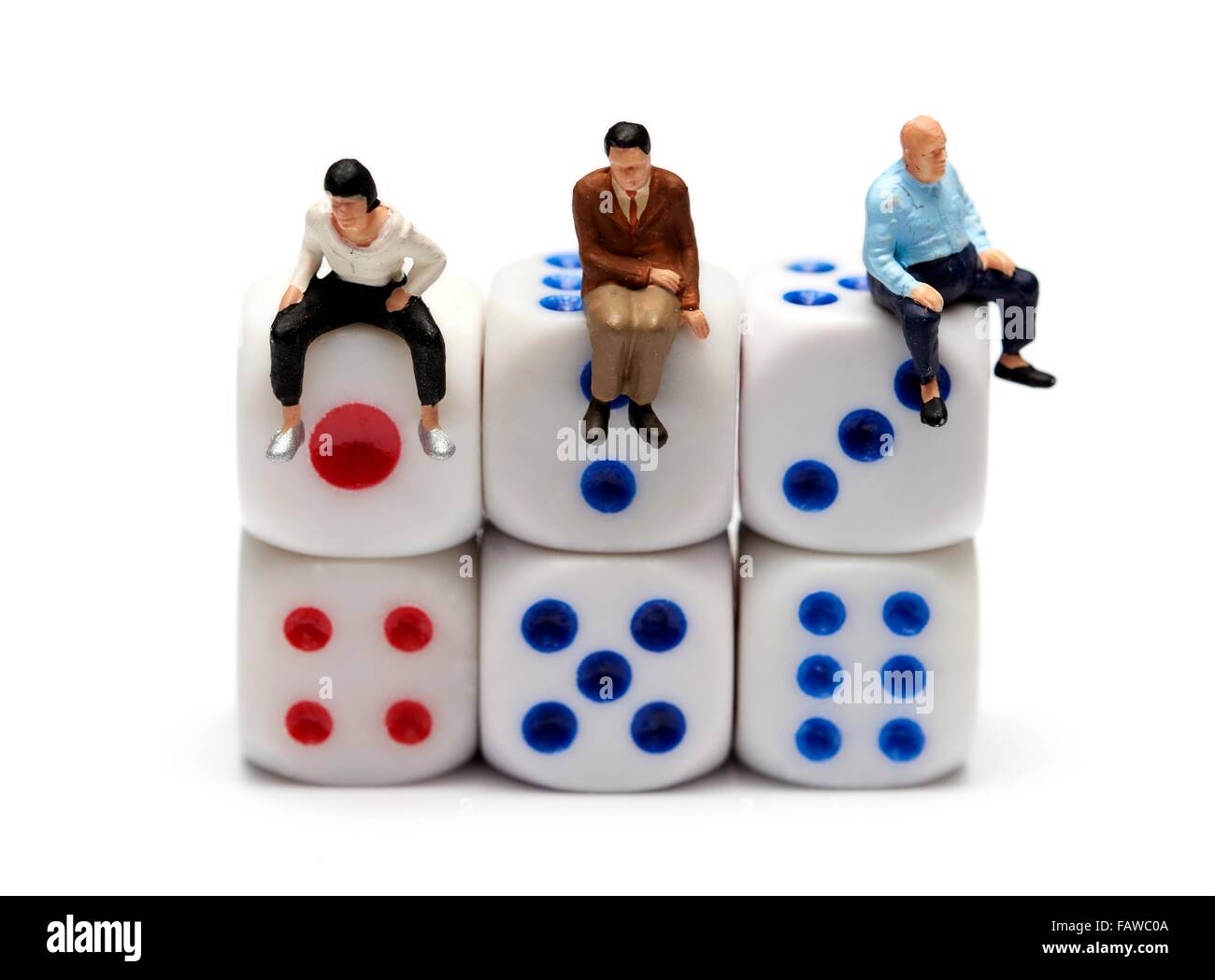 3 persone in miniatura seduta su alcuni dadi Foto Stock