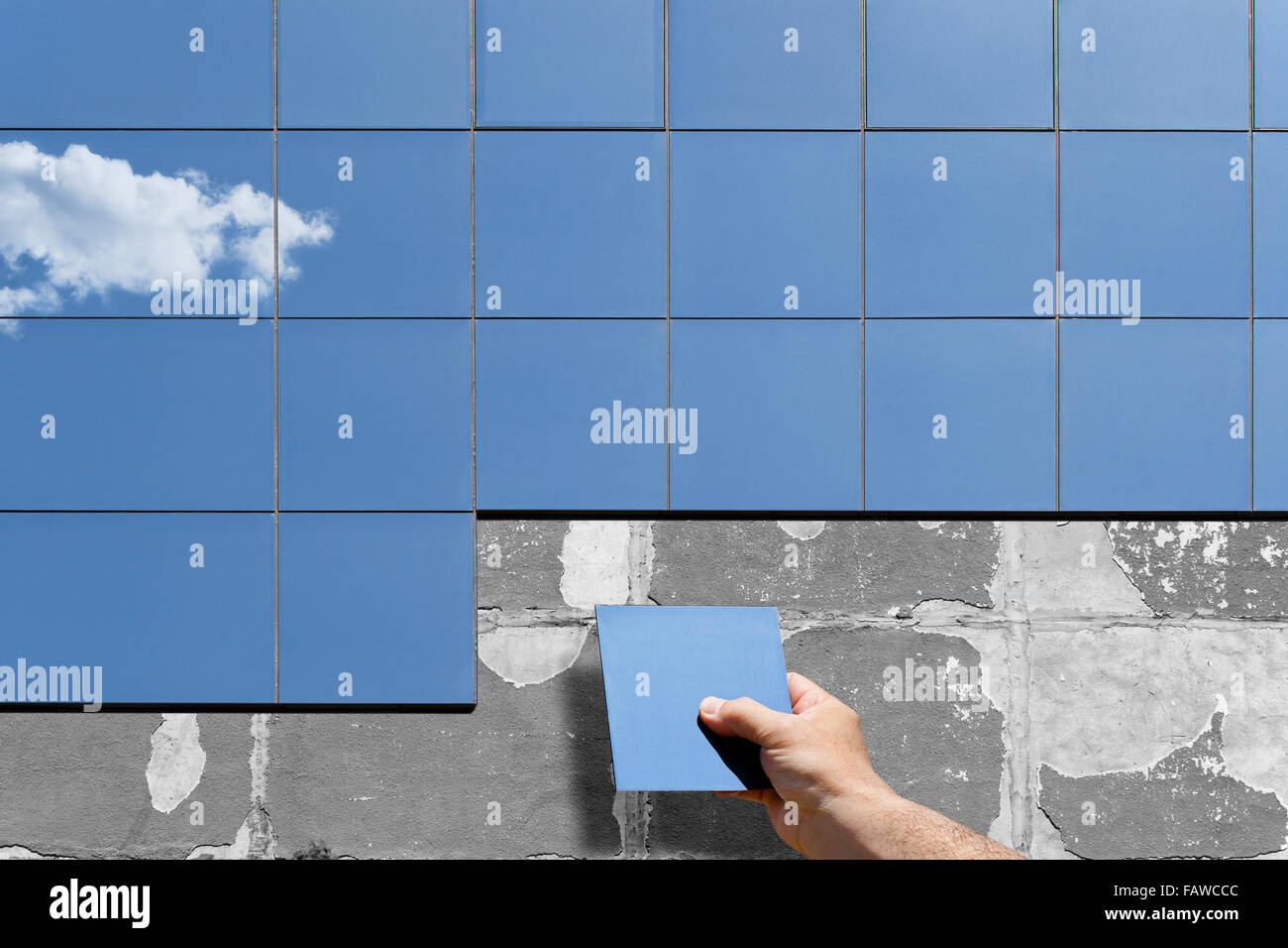Immagine concettuale di un rinnovo e di isolamento della parete di un vecchio edificio. Una mano umana pone e monta il nuovo vetro moderno plat Foto Stock