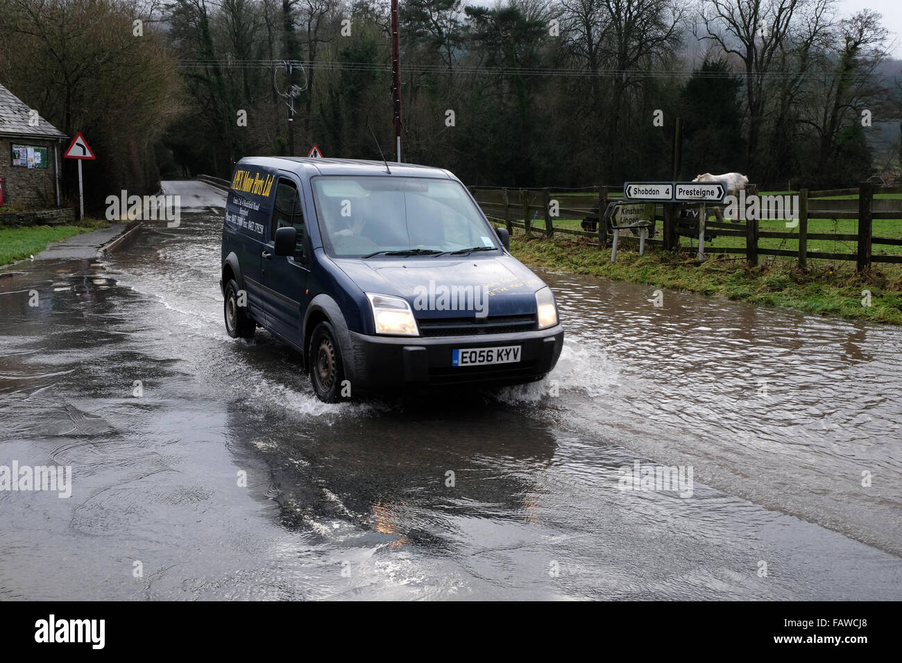 Combe, Herefordshire, UK. 5 gennaio 2016. Un furgone negozia l'allagato B4362 a Combe sul confine England-Wales che collega Presteigne, Powys con Shobdon, Herefordshire. Il locale Hindwell Brook ha scoppiare le sue banche come grandi volumi di acqua continuano a fluire verso il basso da monte in Galles. Foto Stock