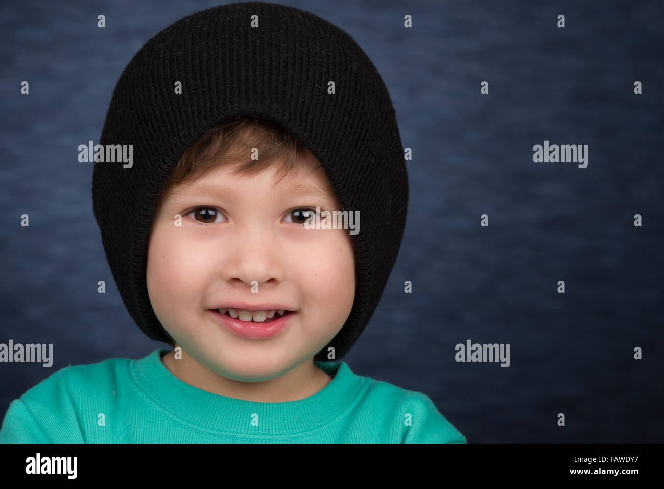 Un sorridente giovane ragazzo che indossa una maglia Cappello invernale. Foto Stock