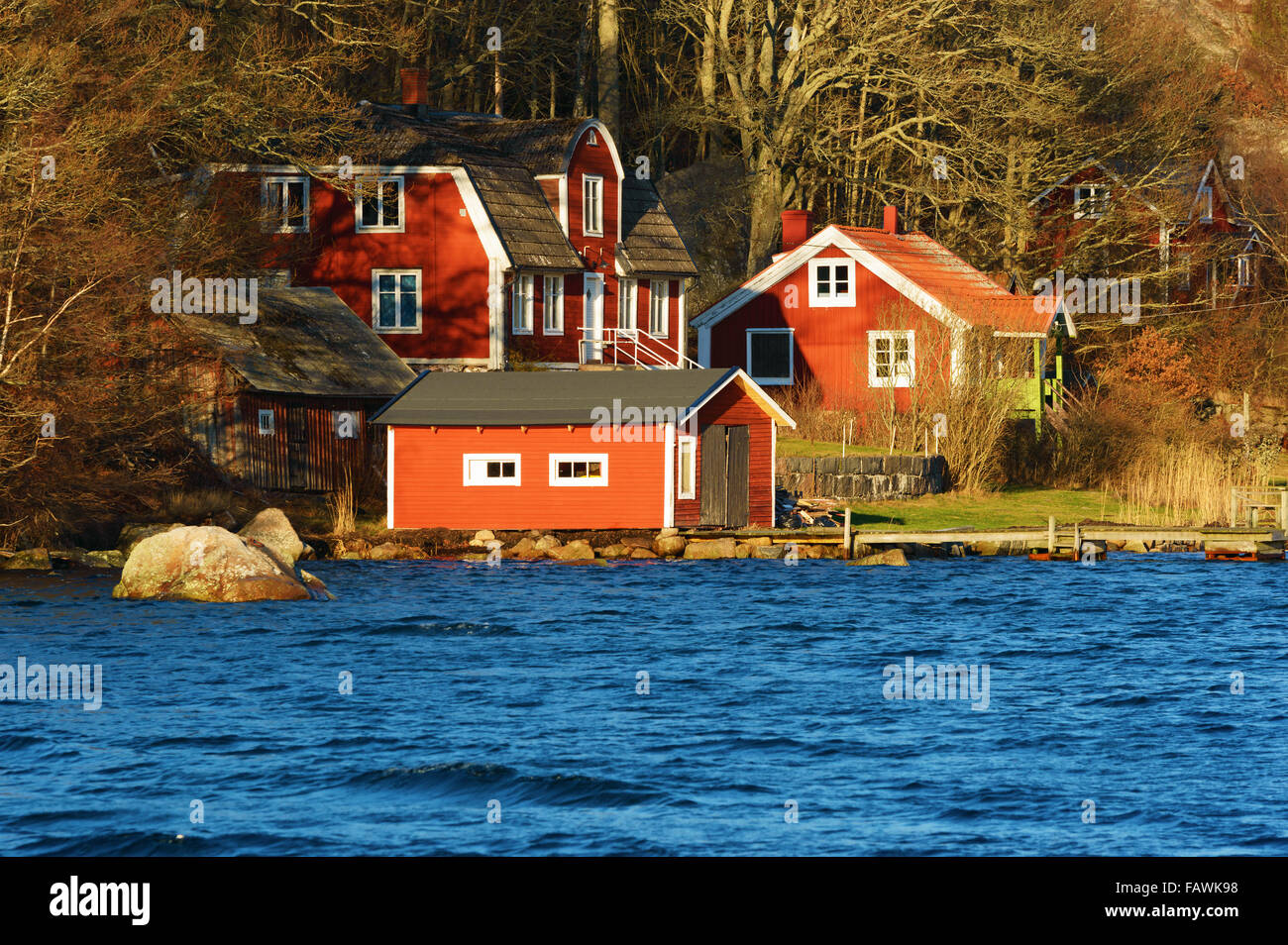 Ronneby, Svezia - 30 dicembre 2015: incantevole red homestead vicino all'acqua. Una legge che chiede il rimborso sui mutui è suggerito di Foto Stock