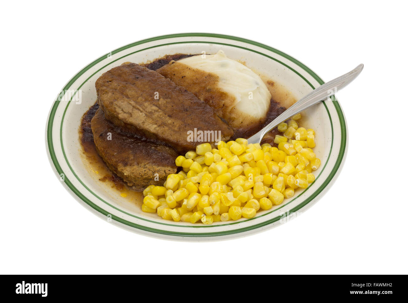 Un polpettone cotto in forno a microonde con il sugo di carne e purè di patate e grano TV cena su una piastra più una forcella inserita nel cibo Foto Stock