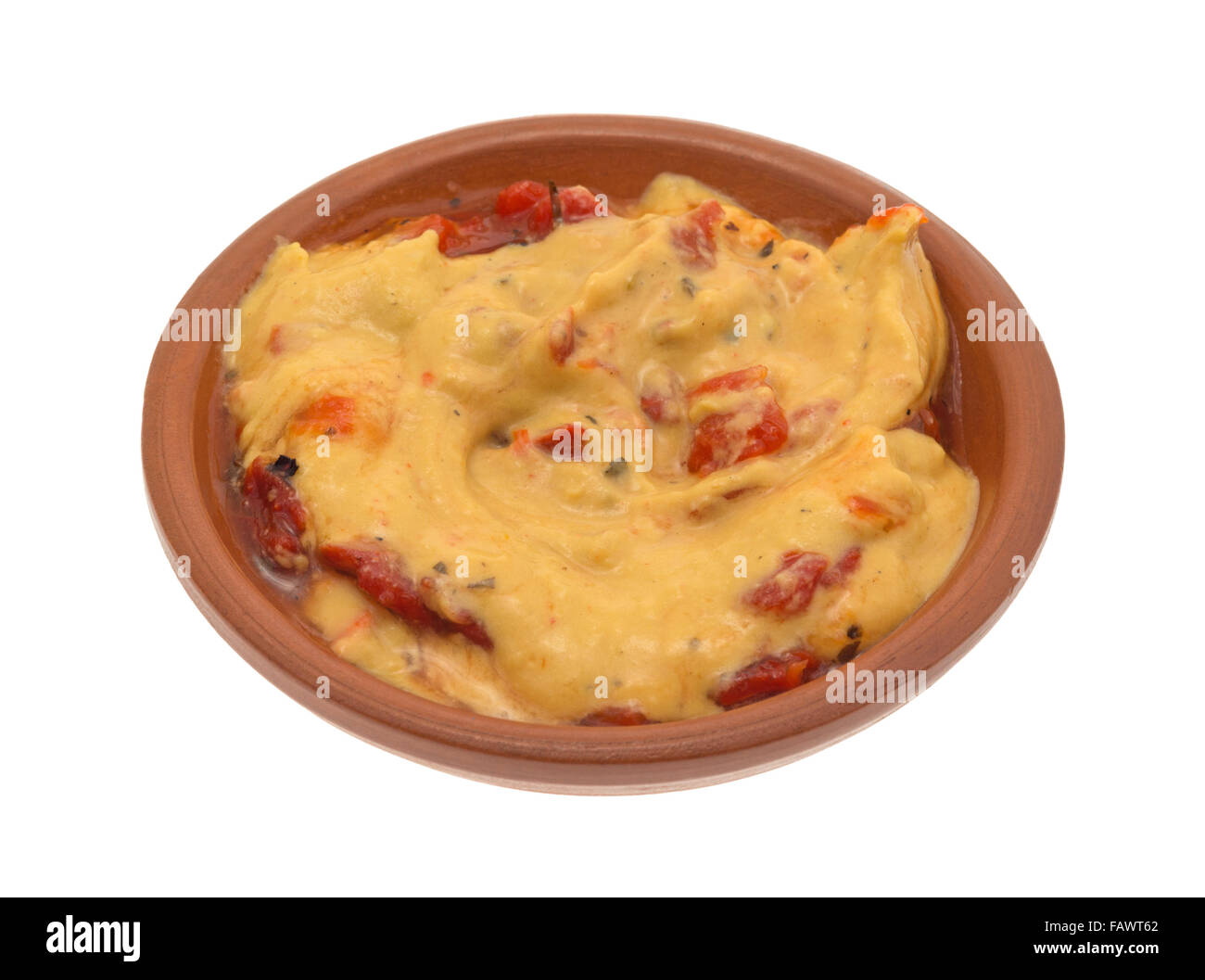 Una piccola ciotola con un serving di hummus con peperoni rossi isolato su uno sfondo bianco. Foto Stock