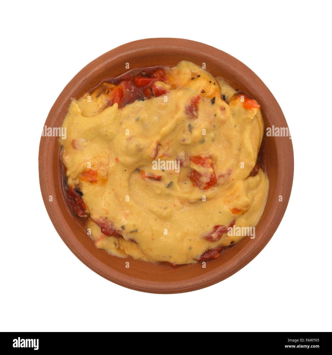 Vista dall'alto di una piccola ciotola con un serving di hummus con peperoni rossi isolato su uno sfondo bianco. Foto Stock