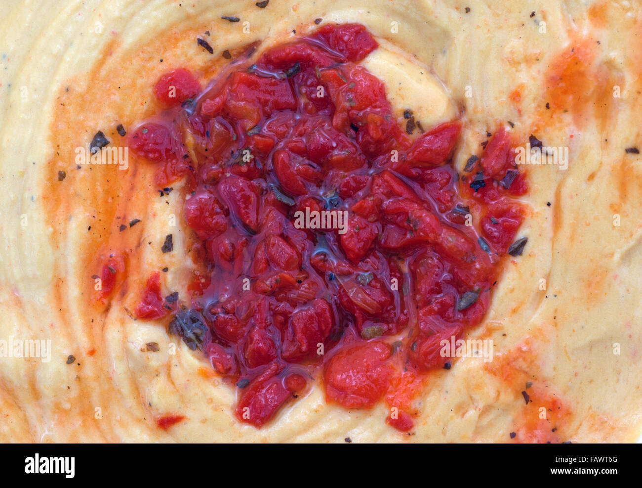 Vista ravvicinata di hummus con peperoni rossi. Foto Stock