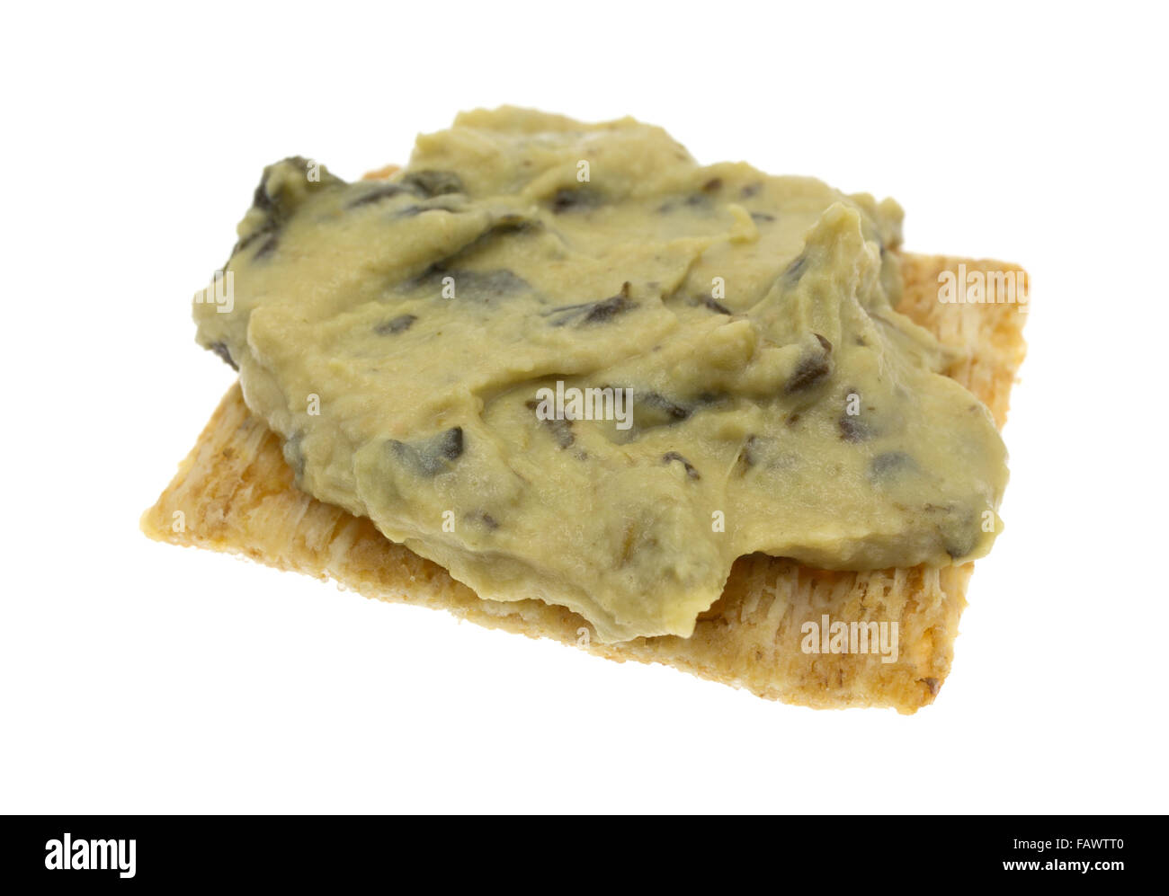 Una porzione di spinaci hommus su un grano intero cracker isolato su uno sfondo bianco. Foto Stock