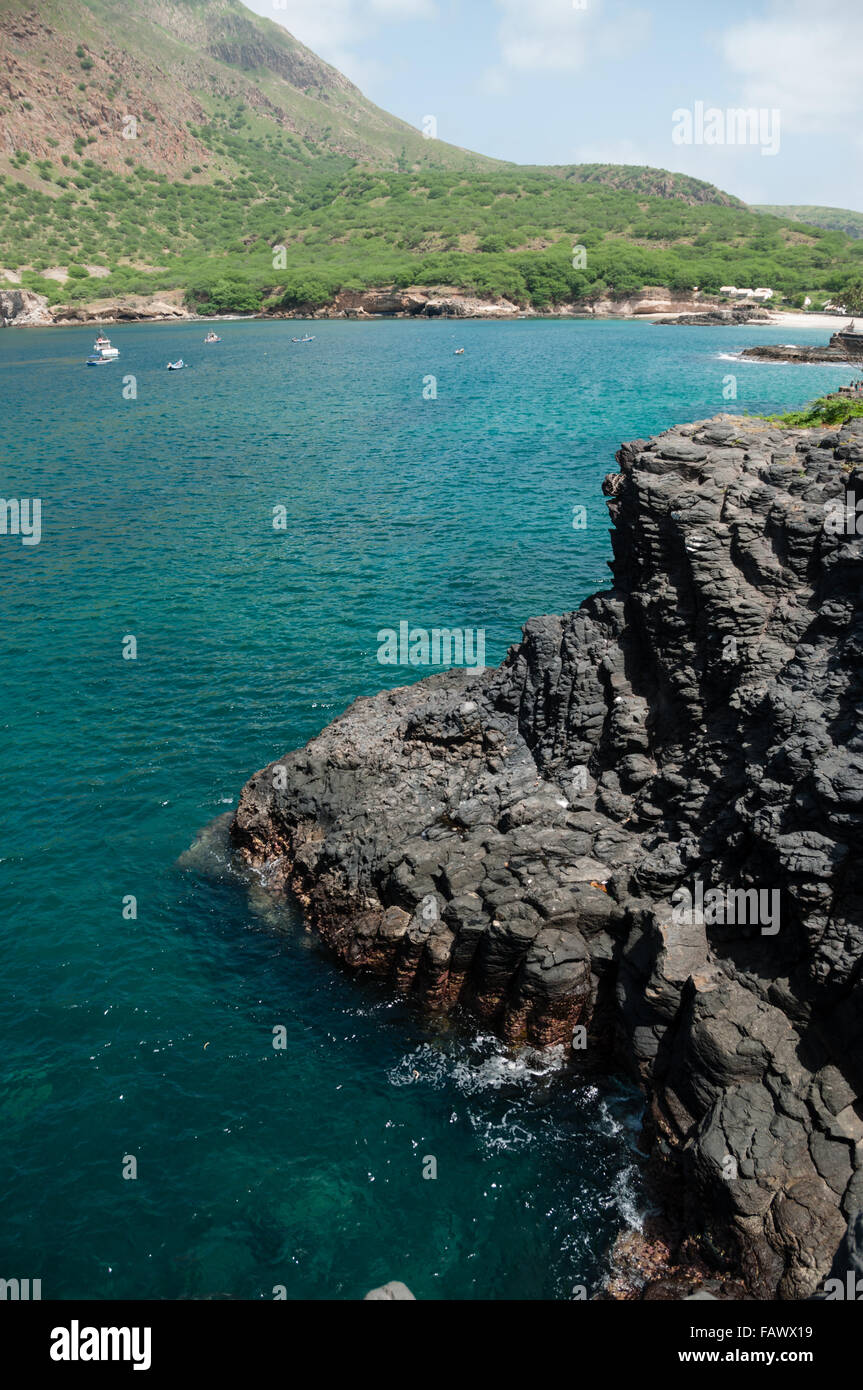 Dark black rock cliff e blu oceano costa Foto Stock