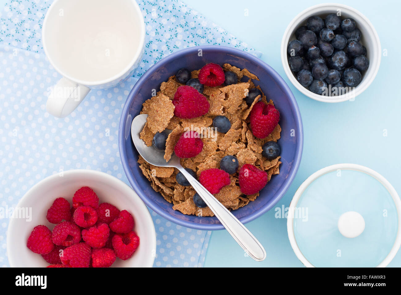 Una sana colazione a base di cereali, di lamponi e mirtilli. ripresa dall'alto guardando verso il basso sulla tabella. Foto Stock