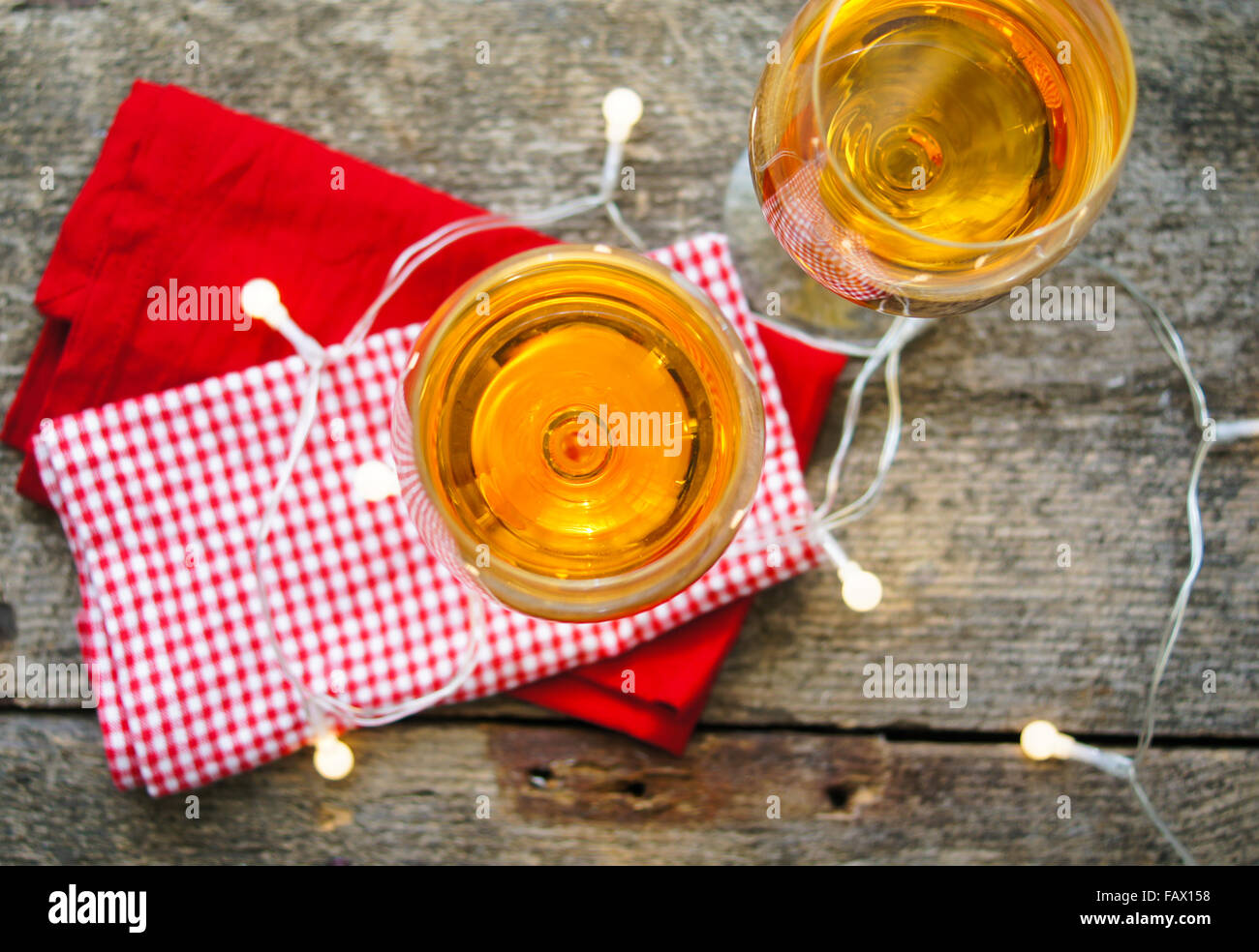 Bicchiere di vino bianco con luci sul vecchio tavolo in legno Foto Stock