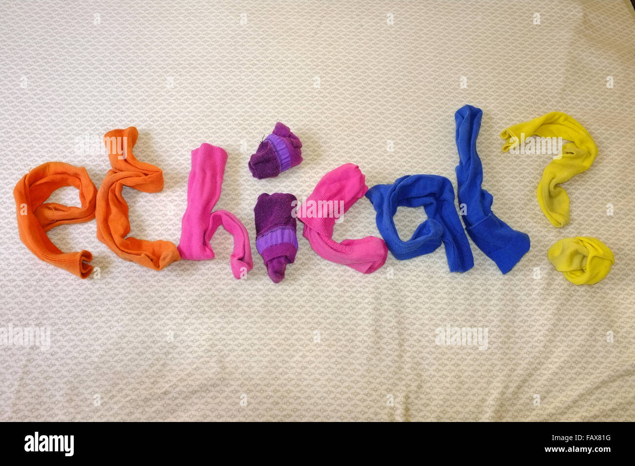 La parola etico? Fatta di calze colorate posa su un piumone. Foto Stock