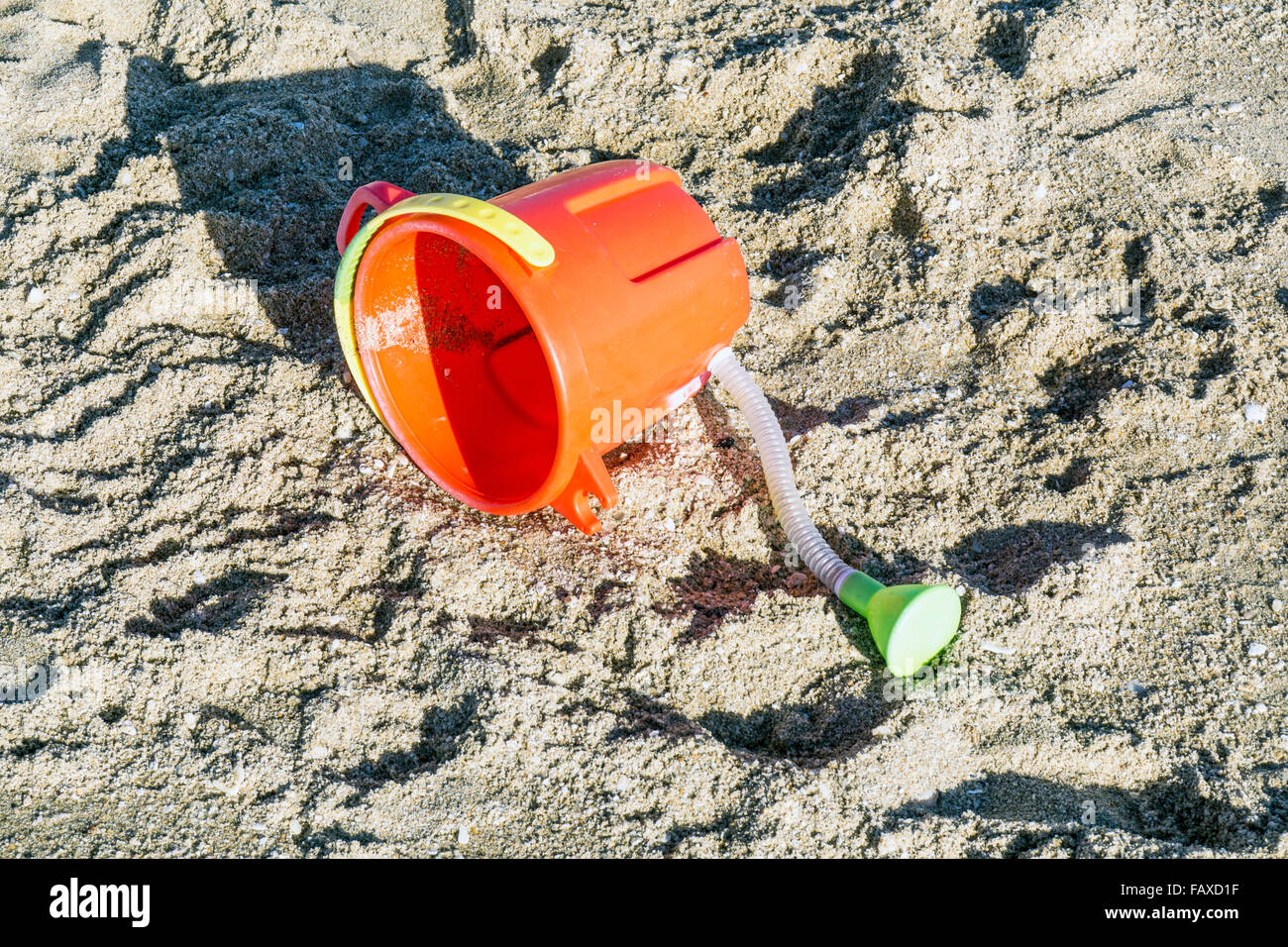 Arancio brillante Annaffiatoio in plastica verde con beccuccio e manico giallo bambino giocattolo lasciato sulla spiaggia a Playa Las Conchas Sonora membro Foto Stock