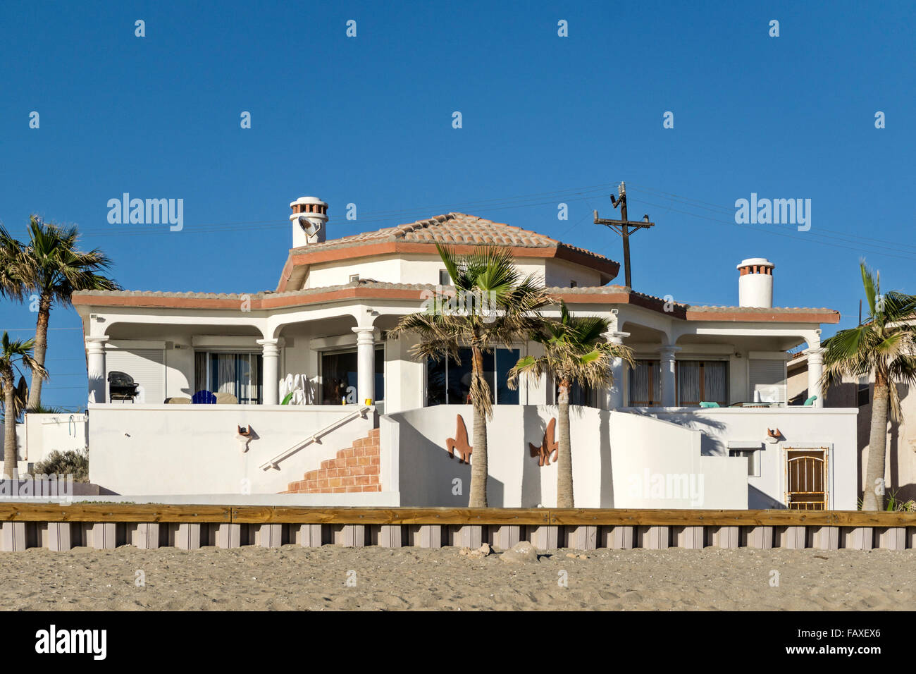 Tipico speculatore costruito spec singoli house villa con veranda con patio e piantate palme sulla spiaggia a Playa Las Conchas Foto Stock