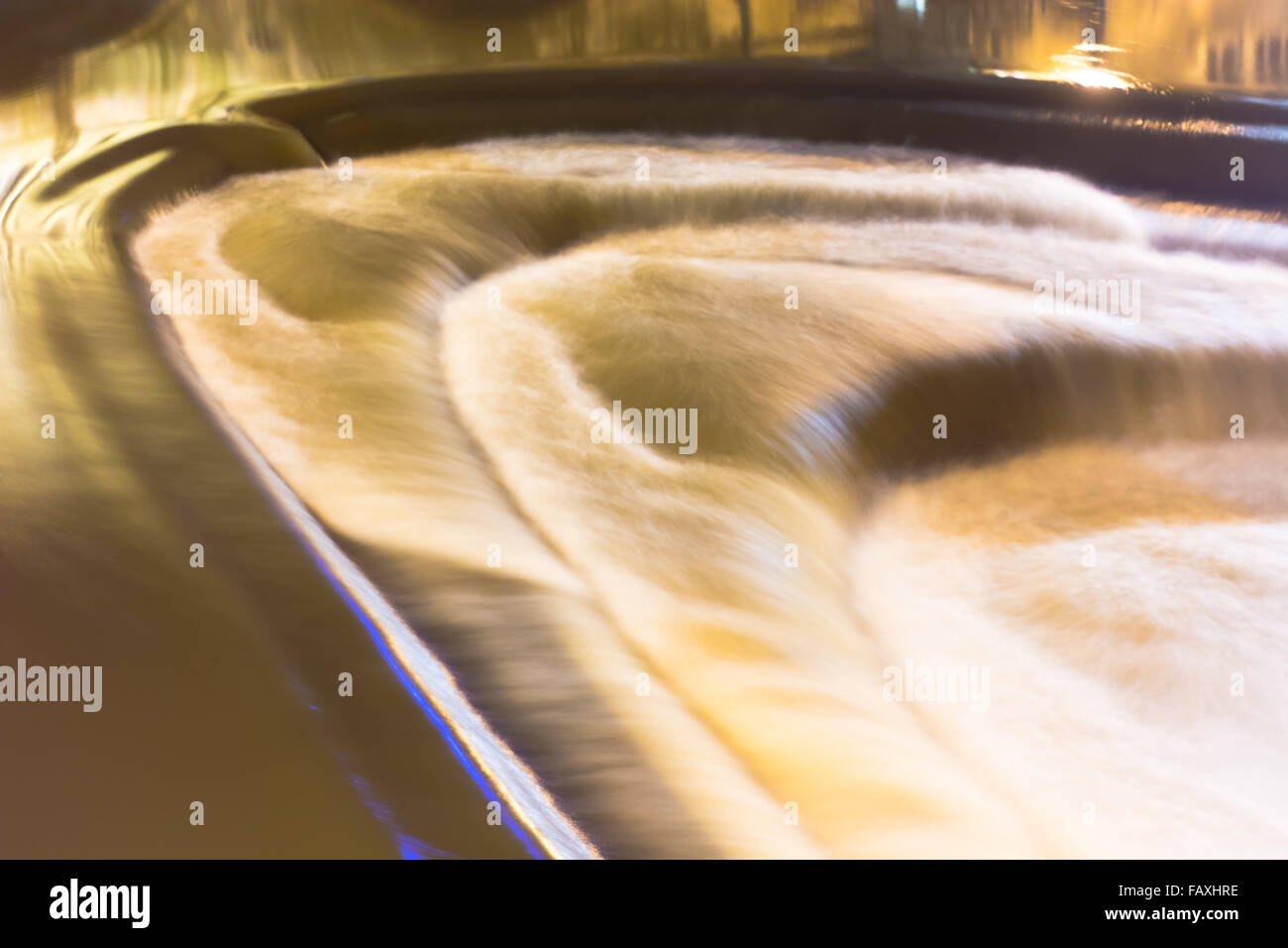 Elevata portata d'acqua sulla Pulteney Weir nel centro di Bath, Somerset, Regno Unito. Una lunga esposizione che mostra la turbolenza nel fiume Avon Foto Stock