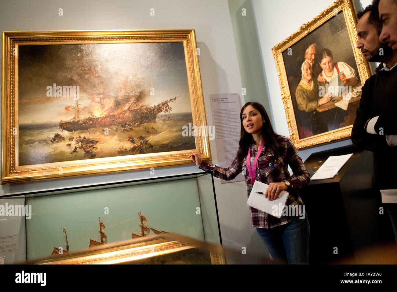Berlino, Germania. Xvi Dec, 2015. Rita Albahri da Damasco, Siria, elabora le specifiche della pittura 'Untergang des Auswandererschiffes Austria" (lit. Naufragio della nave di emigrazione Austria) dal pittore Josef Carl Berthold Puettner come essa serve come una guida per i partecipanti di lingua tedesca per la classe i rifugiati nella "storia tedesca in immagini e documenti " mostra presso il Museo Storico Tedesco a Berlino, Germania, 16 dicembre 2015. Foto: KLAUS-DIETMAR GABBERT/dpa/Alamy Live News Foto Stock