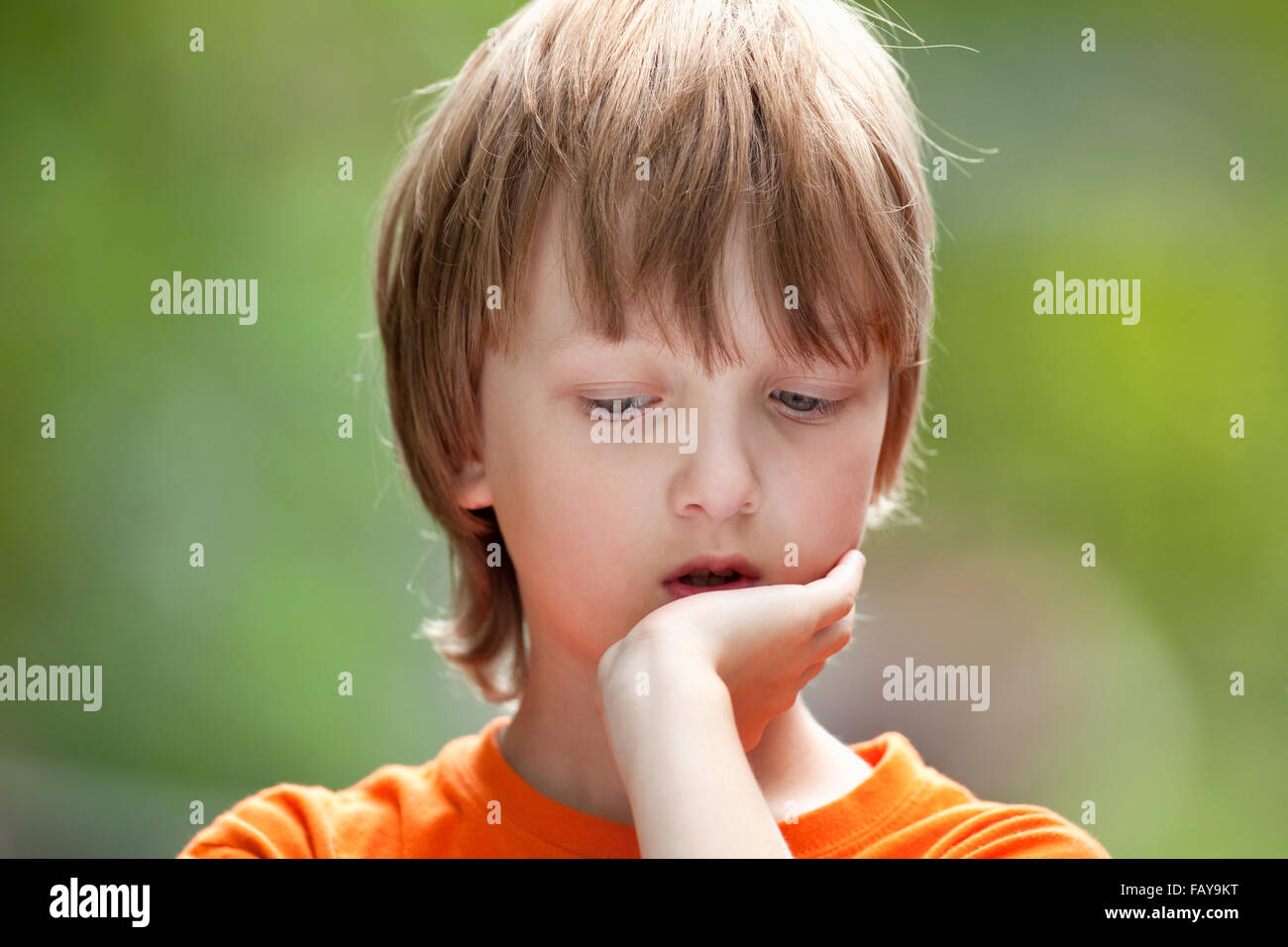 Ritratto di un ragazzo con capelli biondi pensare Foto Stock