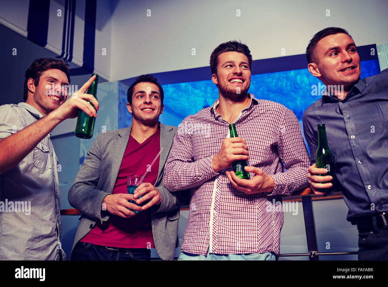 Gruppo di amici maschi con la birra in discoteca Foto Stock