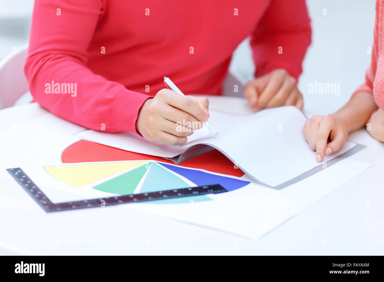 Due colleghi consulting oltre il taccuino di scrittura. Foto Stock