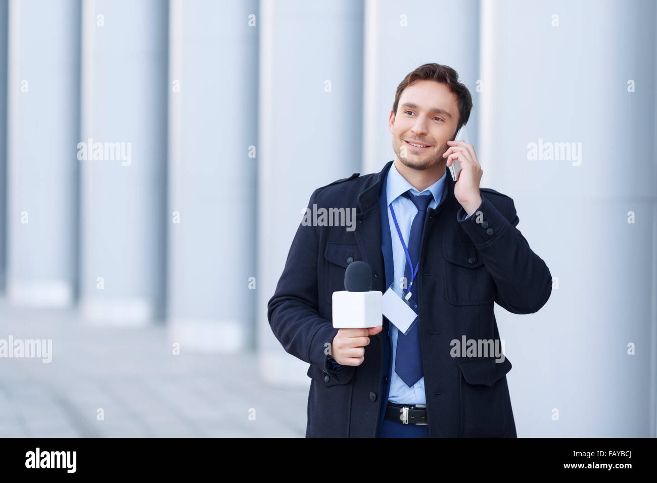 Newsman sorridente sta parlando al telefono. Foto Stock