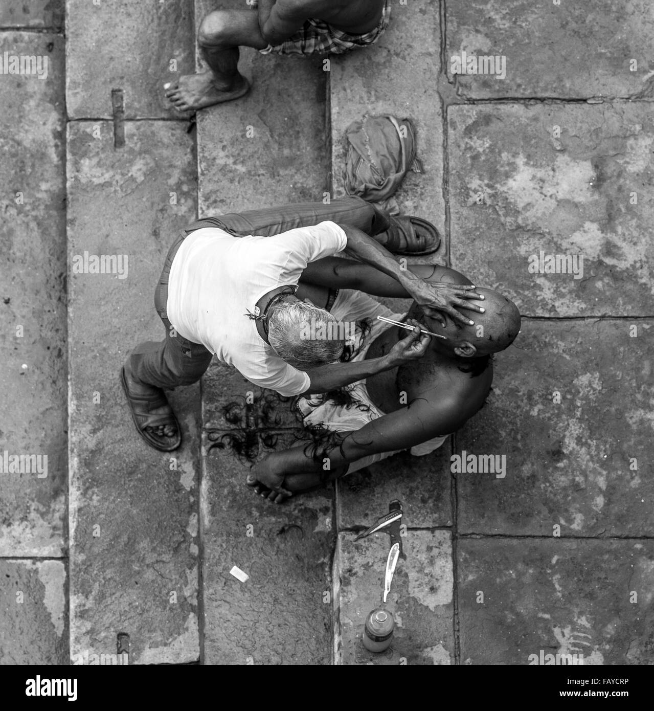Barbiere sui ghat Varanasi, India Foto Stock