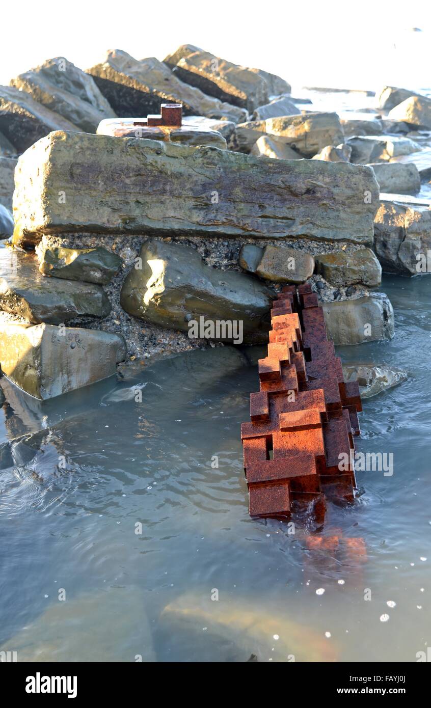 I caduti ghisa scultura chiamato 'terra' di Antony Gormley a Kimmeridge Bay nel Dorset, in Gran Bretagna, Regno Unito Foto Stock