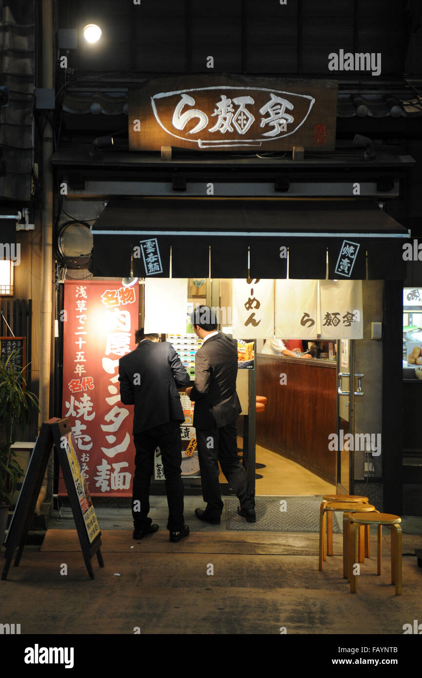 Due uomini di affari presso l'entrata di un ristorante giapponese in Asakusa Tokyo Giappone Foto Stock