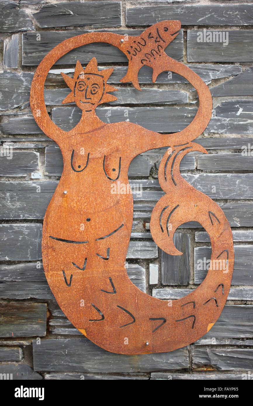 Scultura di metallo di una sirena tenendo un pesce Foto Stock