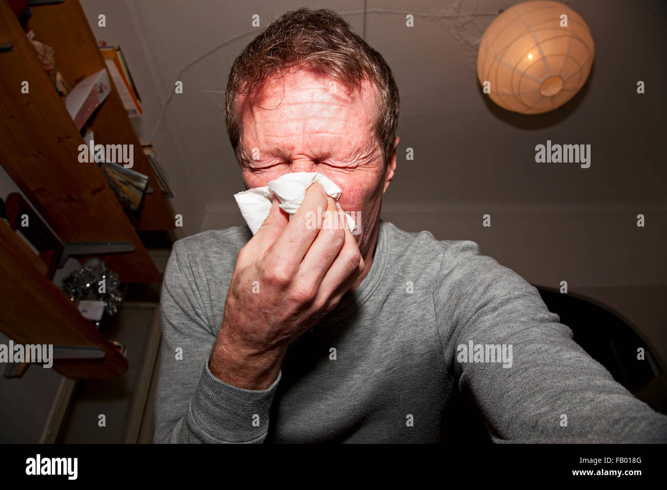 L'uomo soffia il naso durante un attacco d' asma. Foto Stock