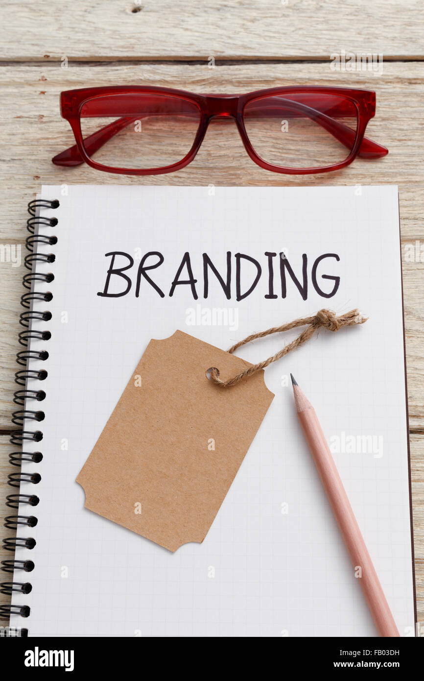 Concetto di branding con marchio tag, glassess e matita su notebook Foto Stock
