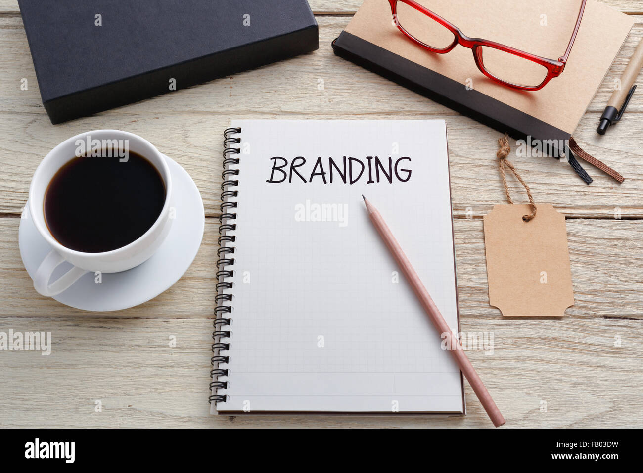 Concetto di branding con marchio di notebook tag e la confezione del prodotto sul banco di lavoro Foto Stock