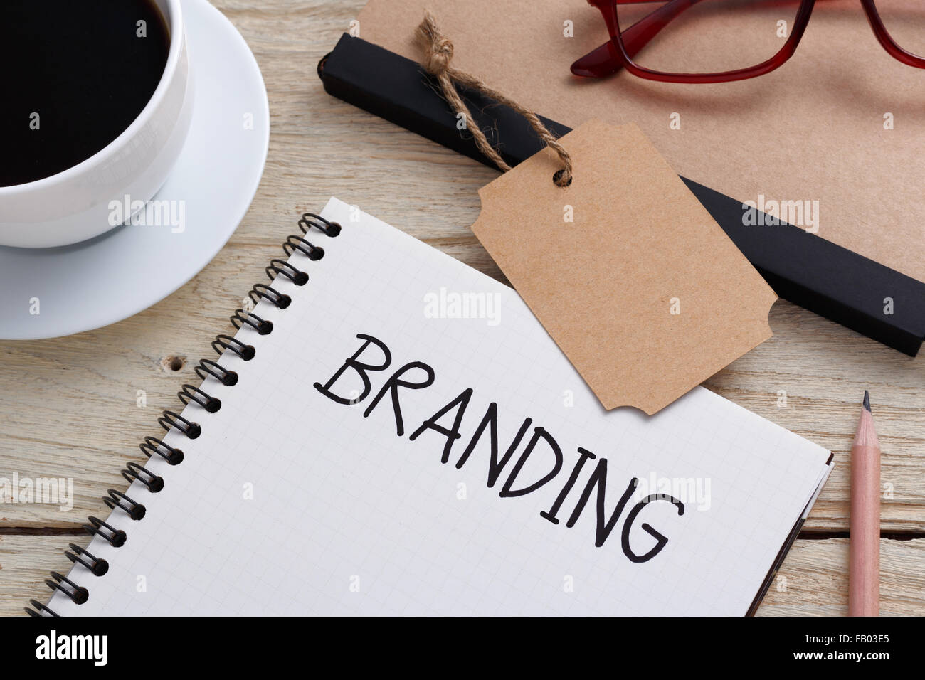 Concetto di branding con marchio di notebook tag e tazza di caffè sulla scrivania Foto Stock