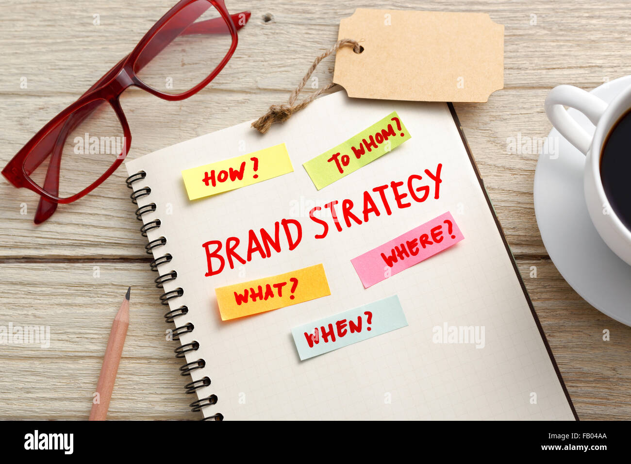 Brand Marketing il concetto di strategia con i notebook, marchio di tag e occhiali sulla scrivania in ufficio Foto Stock