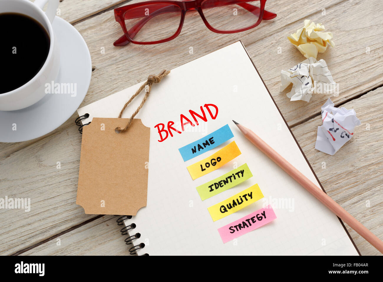 Brand Marketing concetto con notebook, tag di marca e la tazza di caffè sulla scrivania in ufficio Foto Stock