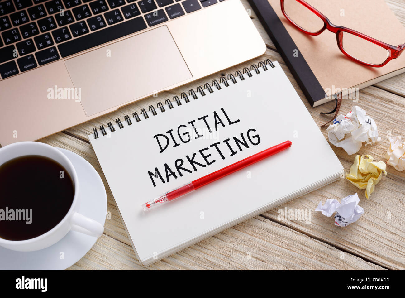 Marketing digitale nota della scrittura con il computer portatile e la tazza di caffè sulla scrivania in ufficio Foto Stock