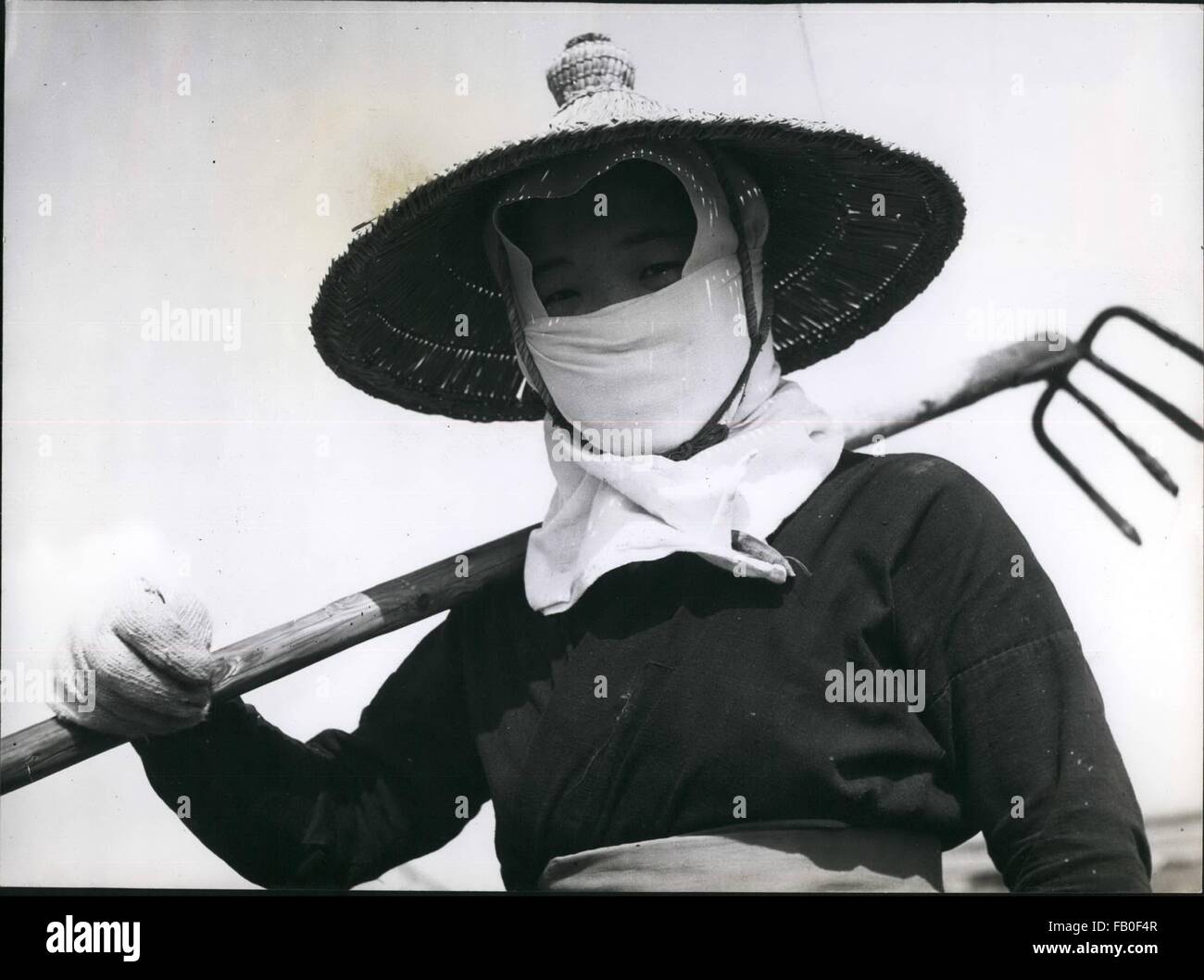 1962 - Un giapponese la moglie di un agricoltore è ben attutiti fino per giornata di lavoro nei campi. La hat protegge il suo dal sole e la maschera per il viso protegge dal suo spessore, polvere secca. © Keystone Pictures USA/ZUMAPRESS.com/Alamy Live News Foto Stock