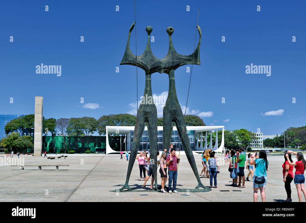 Il Brasile, Brasilia: turisti tenendo snap shots con telefoni intelligenti a 'Os Candangos' monumento in Piazza Praça dos Tres Poderes Foto Stock