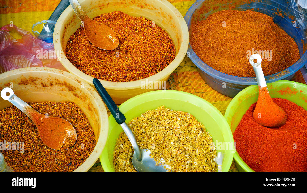 Colorato di peperoncino in polvere e spezie nella benna a fresco del mercato locale a Luang Prabang, Laos Foto Stock