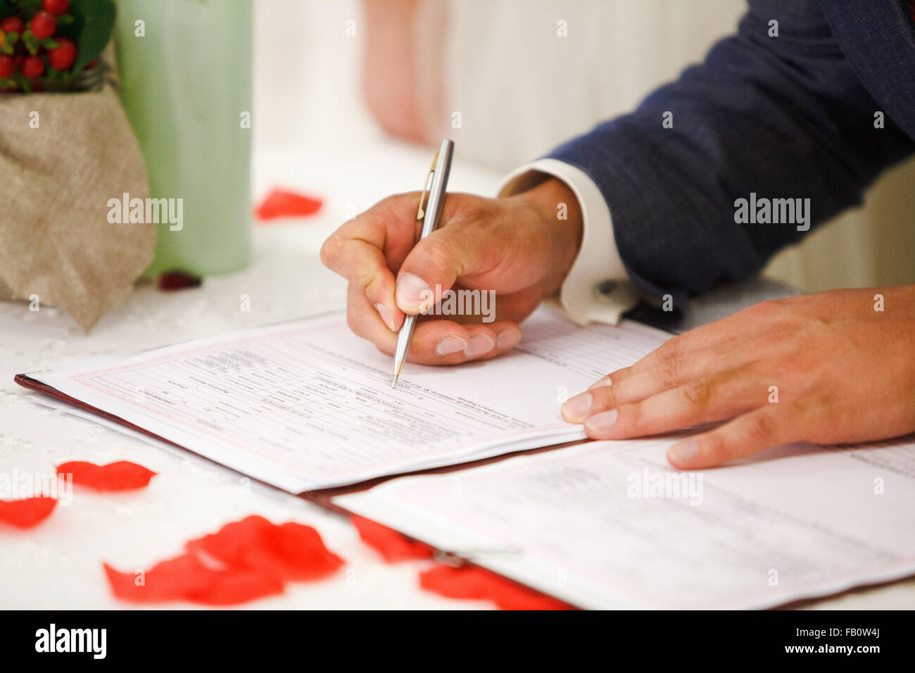 Lo sposo segni il certificato di matrimonio con una penna Foto Stock