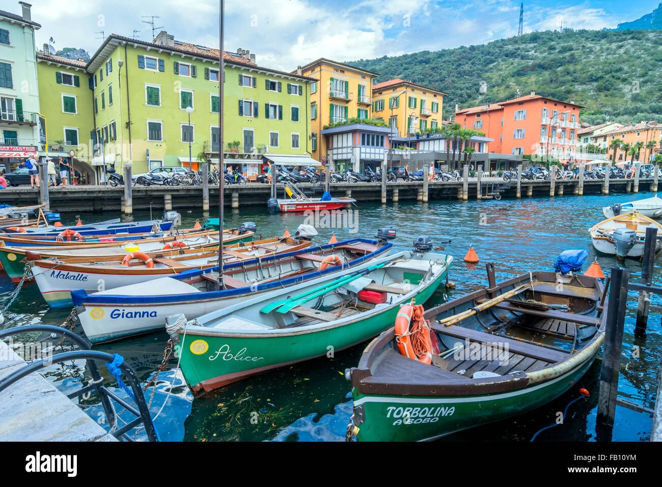 Lago di Garda boardwalk con le case, i turisti e le barche a Torbole, Italia. Foto Stock