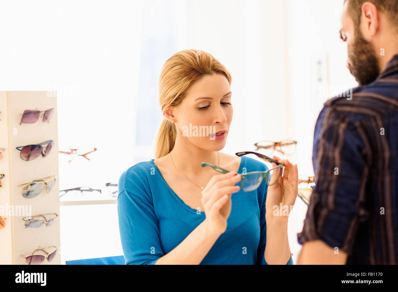 La donna e l uomo la scelta di occhiali in negozio Foto Stock