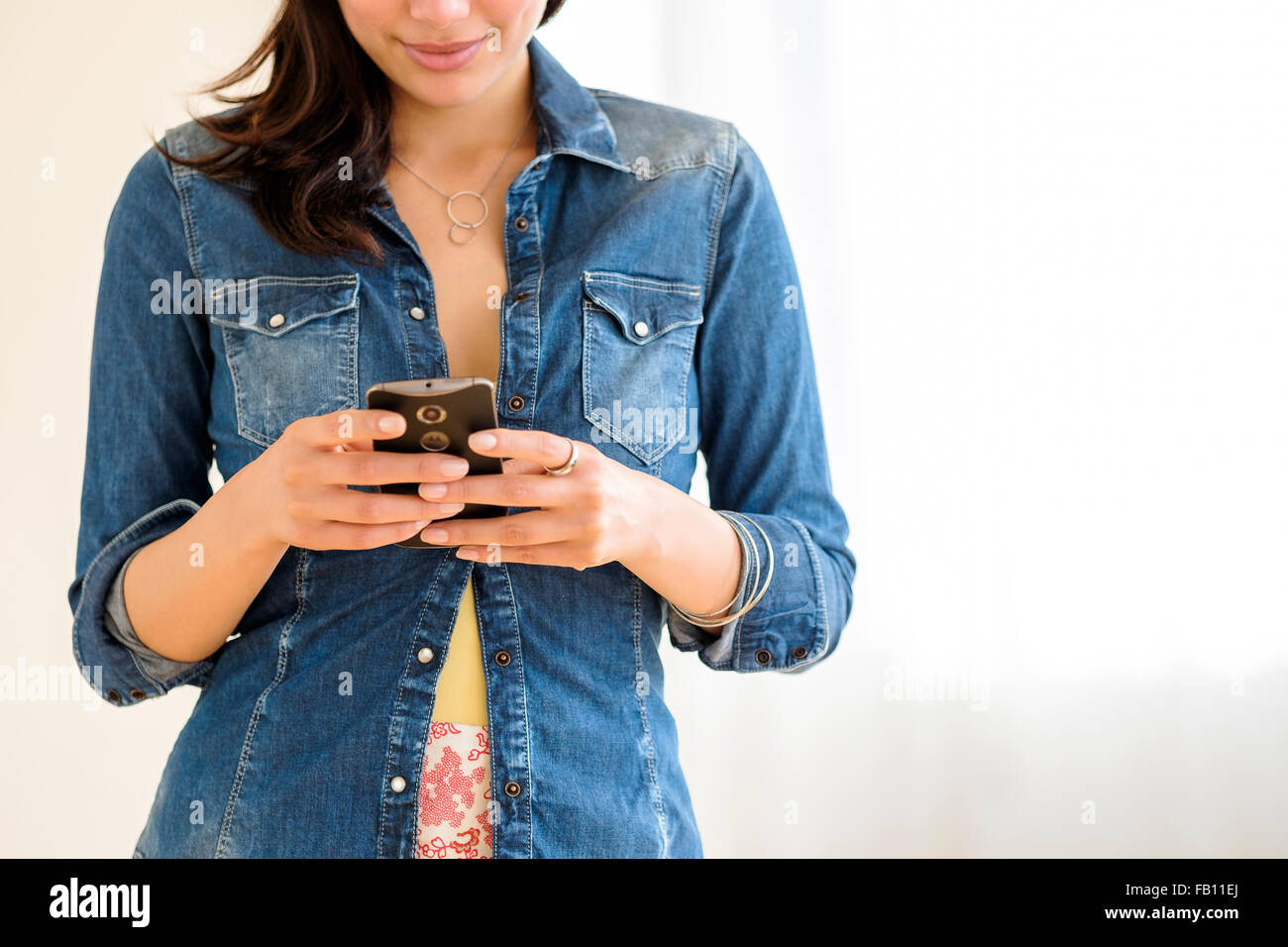 Sezione centrale della giovane donna texting Foto Stock