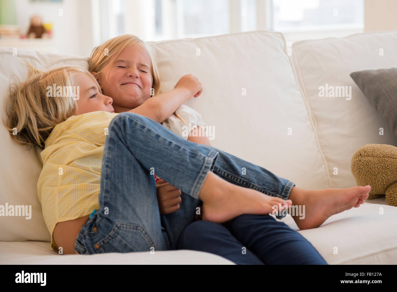Ragazzo (4-5) e la ragazza (6-7) costeggiata sul divano Foto Stock