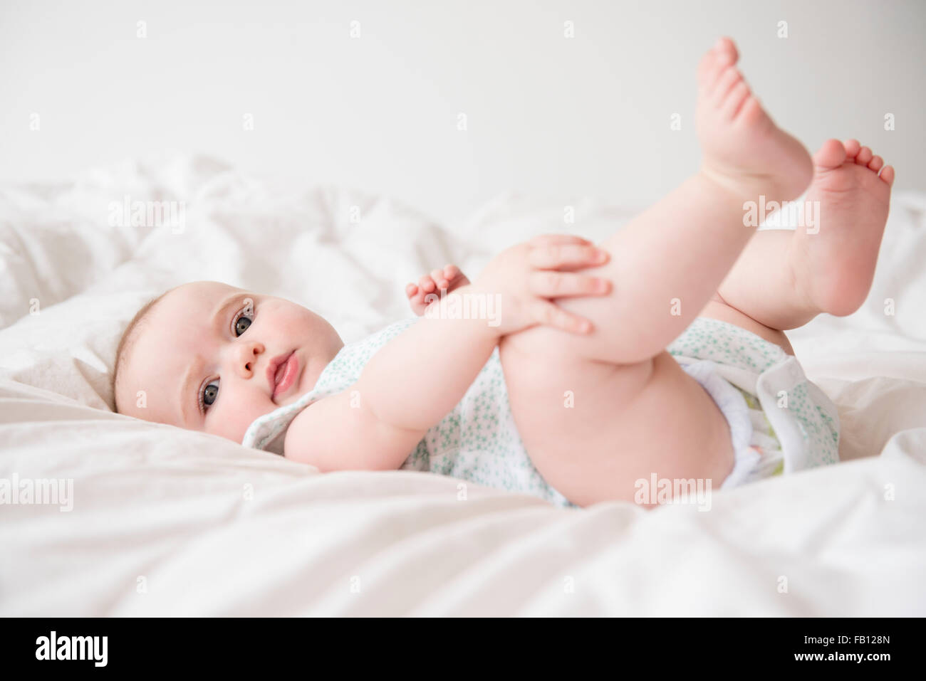 Baby girl (12-17 mesi) sdraiato sul letto Foto Stock
