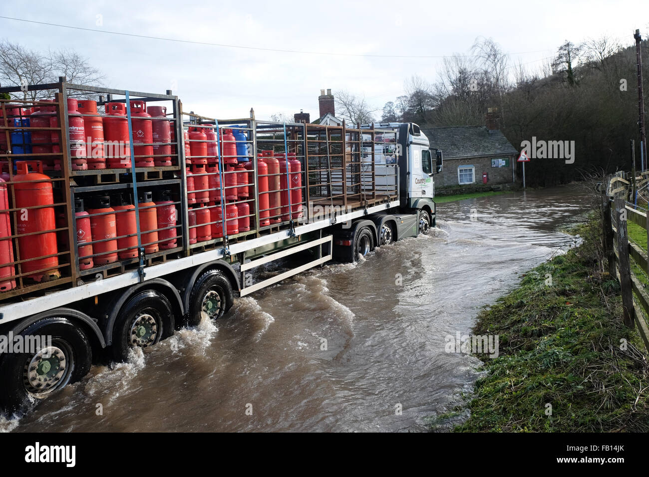 Combe, Herefordshire, UK. Il 7 gennaio, 2016. Un camion che trasportano gas GPL aziona i cilindri attraverso l'acqua di allagamento sul allagato B4362 a Combe sul confine England-Wales che collega Presteigne, Powys con Shobdon, Herefordshire. Foto Stock