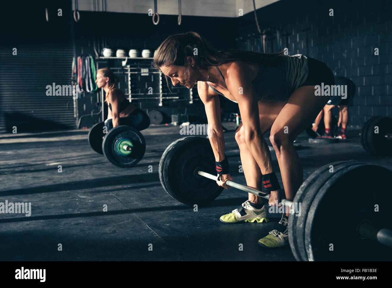 La formazione delle donne con barbells in palestra Foto Stock