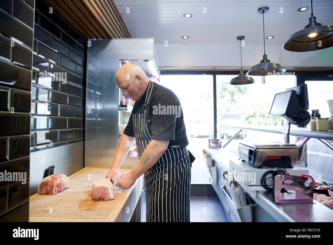 Coppia butcher preparare la carne in negozio di macellaio Foto Stock