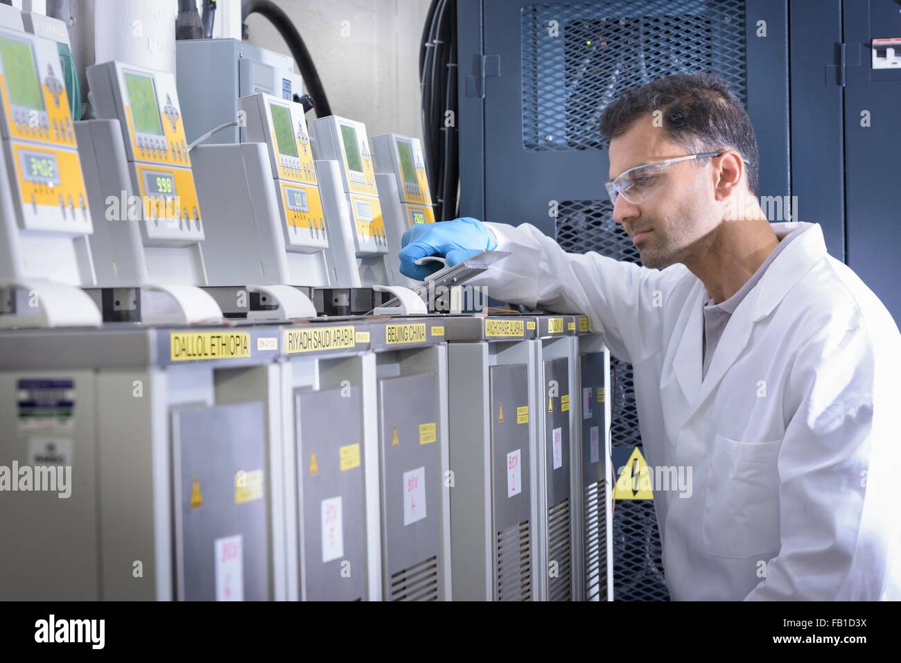 Scienziato con batteria agli ioni di litio invecchiamento attrezzature in batteria in un centro di ricerca Foto Stock